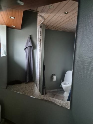 Anmelder viser et blankt og stribefrit spejl efter brug af den magiske rengøringsklud.