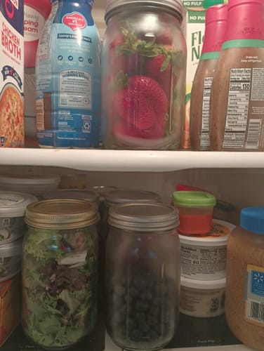 Customer's refrigerator with strawberries, salad, and blueberries kept fresh in three sealed mason jars.