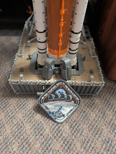 Customer's embroidered Artemis II Collectors Patch displayed in front of a large model rocket.