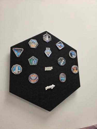 Reviewer's Starship Flight Pin Collection on the black hexagonal display mount, shown hanging on a wall.