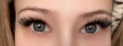 Nahaufnahme einer Kundin, die die langen 'So Foxy' Wimpern für einen dramatischen Cat-Eye-Look trägt.