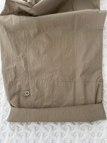 Customer's khaki Barrel Leg Pants with the cuff rolled up, showing the button detail at the ankle.