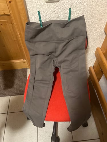 Ein Kunde zeigt seine graue Tofana-Leggings mit hohem Bund, die über einen Stuhl gehängt ist.