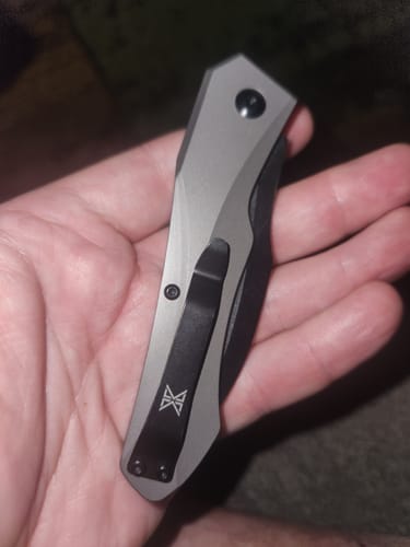 Customer holding the closed Hendrix Titanium Switchblade in their palm, showing the titanium handle and black clip.