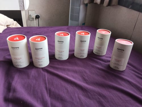Customer's six perfume packages, including After Hours, arranged on a purple bedspread.