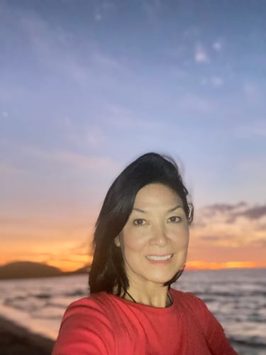Customer showing her clear facial skin outdoors at sunset after using Sun Shield Cream.