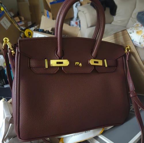 Customer's structured Warkin Bag in a pebbled wine color, featuring its gold lock closure.