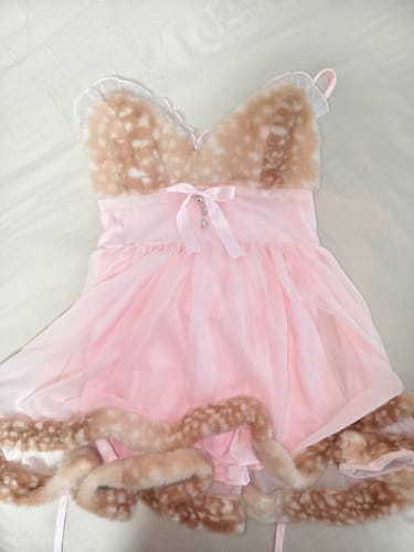 Customer's photo of a pink dress with spotted faux-fur trim laid flat on a white surface.