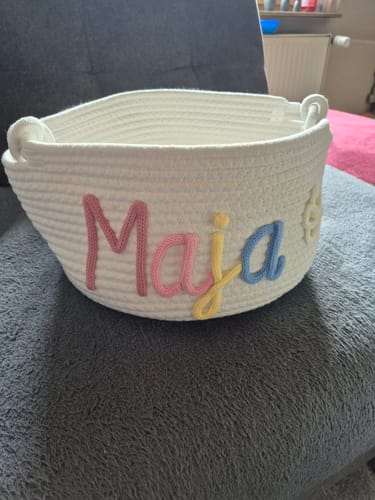 Customer's white basket personalized with the name 'Maja' in colorful letters and a sun icon.