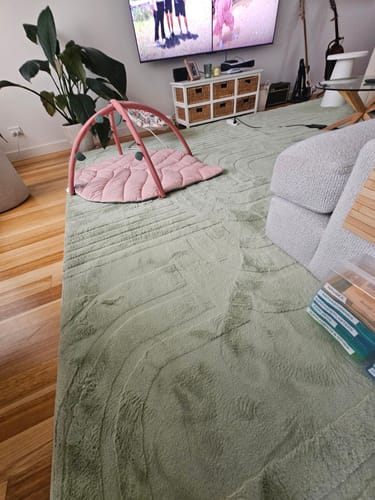 Reviewer's large Pistachio Green Mellow Mat covering a living room floor with a baby play gym on top.