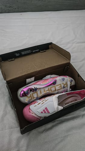 Avis d'un client sur les crampons PREDATOR Elite blancs et roses dans leur boîte.