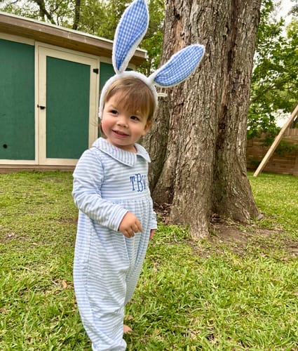 Customer wearing the monogrammed French Blue Stripe Romper and fun bunny ears outdoors.