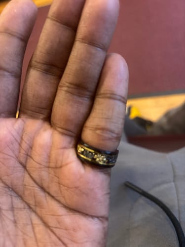 Close-up: Customer's hand wearing the black Titanfall ring with its gold and meteorite inlay.