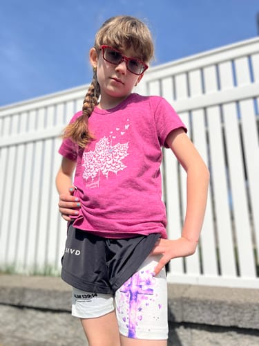 A young person wearing the two-layer Girls Performance Shorts, showing the Psalm 139:14 verse on the white inner layer.