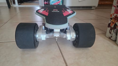 Customer's MEEPO Voyager X electric skateboard from a low rear angle, showing the dual motors and large black wheels.