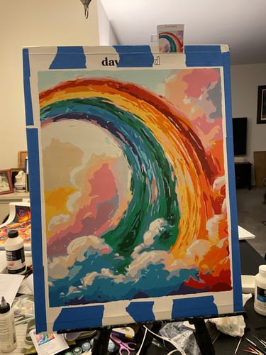 Reviewer's Rainbow Painting paint-by-numbers kit in progress, showing a vibrant, colorful wave on canvas.