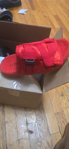 A close-up of a reviewer's red Original Dracoslide resting on top of its open box on a wooden floor.