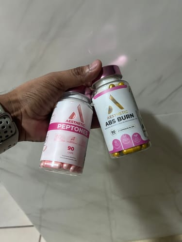 Un cliente sostiene en la mano los dos botes del Kit Aesthetic Body: Aesthetic Abs Burn y Aesthetic Peptones.