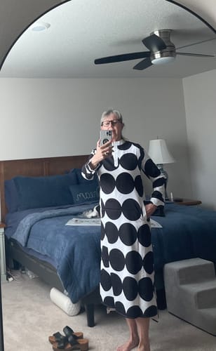 Reviewer taking a mirror selfie to show the fit of the loose, long-sleeved Polka-Dot Midi Dress.