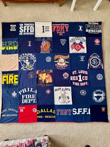Customer's large Premium T Shirt Quilt made from various firefighter t-shirts, including SFFD and FDNY, spread out on a floor.