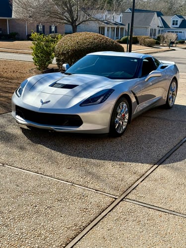 Reviewer's silver Corvette parked on a driveway, protected with a SPOTMINDERS Tracking Card.