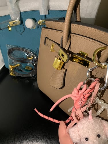 Customer's two new LALUVA Warkin Bags, a beige one in front of a blue one, showing the gold hardware.