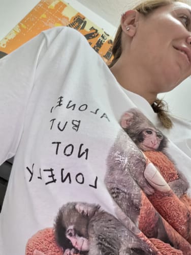 Una clienta muestra un primer plano de su camiseta Punch con el estampado de un mono.