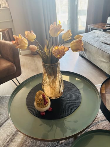 Klant toont de prachtige Papegaai Tulpen in een vaas op een salontafel.