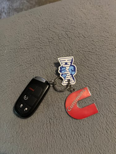 Customer's red Cummins C-logo keychain shown on a keyring with a car key fob.