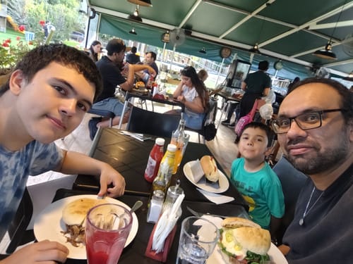 Cliente en un restaurante llevando el Colgante de Brújula sobre una camiseta oscura.