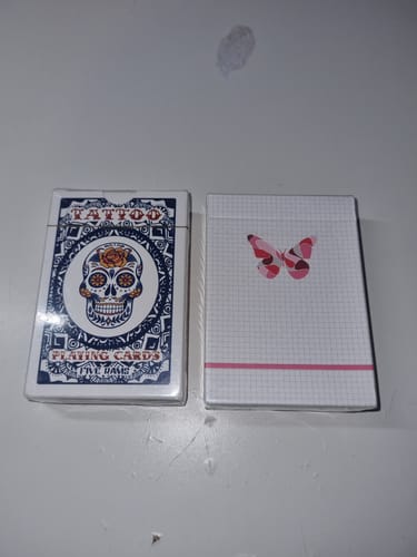 Customer's two Mystery Decks. One has a sugar skull design, the other a pink butterfly on a white grid.