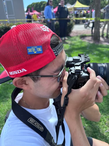 Reviewer outdoors wearing a red hat with a personalized California Blue License Plate Enamel Pin on the side.