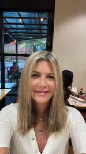 Customer who submitted a review for Meraki Blu, smiling at the camera indoors.