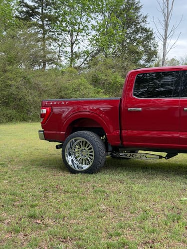 Customer's red Ford F150 showing the installed Traction Bar Kit with a stainless steel overlay.