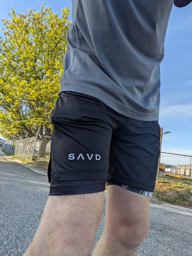Customer wearing the black 'Warrior’s Discipline' Men’s Performance Shorts outdoors, showing the fit and SAVD logo on the leg.