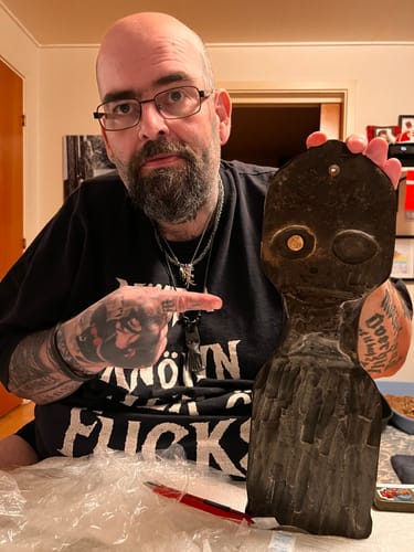 Reviewer proudly holding and pointing at their custom dark Odin figure.