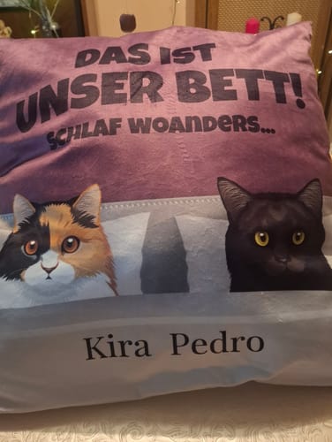 Rezensentenfoto eines personalisierten Kissens mit zwei Katzen, 'Kira' und 'Pedro', und dem Spruch 'Das ist unser Bett!'.