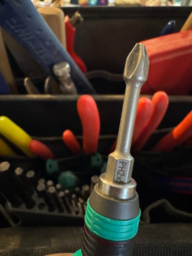 Close-up of a reviewer's Wera Harpoon DC bit attached to a screwdriver handle in front of a toolbox.