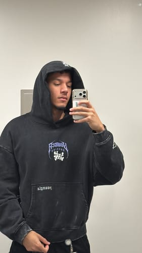 Reviewer taking a mirror selfie while wearing the black Demon Slayer hoodie with the hood up.