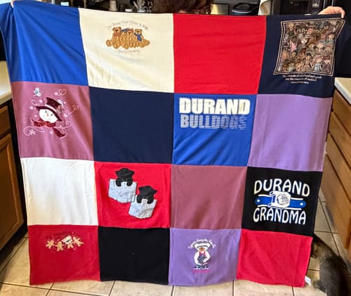 Customer holding up their Project Repat T-Shirt Quilt, a colorful tribute blanket for grandma.