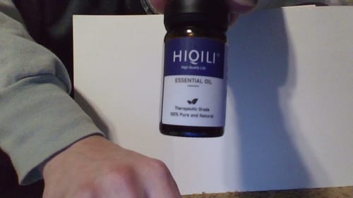 Customer holding a small, dark amber bottle of Patchouli Essential Oil.