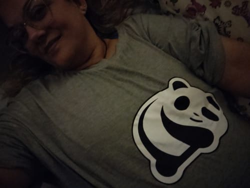 Cliente relaxando enquanto veste a Camisola Pandinha cinza com a estampa de panda.