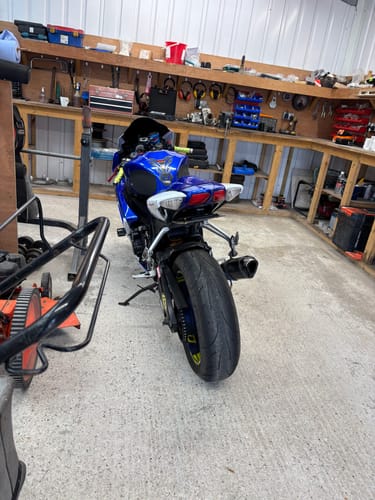Customer's blue Suzuki GSXR 600 with a tail tidy installed, seen from the rear in a workshop.