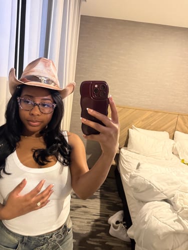 Customer's mirror selfie showing the Hollywood Billion S-BODY hair weave styled under a hat.