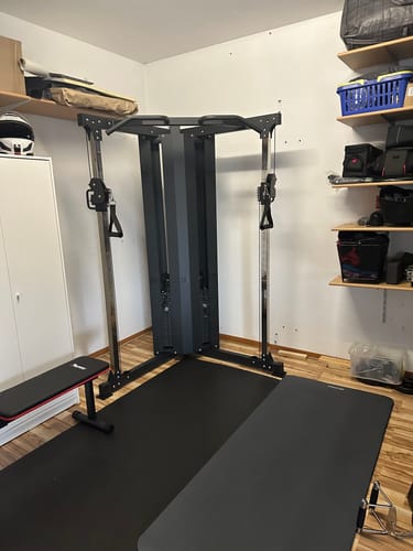 Rezensent zeigt den aufgebauten X-Five Kabelzug in einem Fitnessbereich zu Hause.