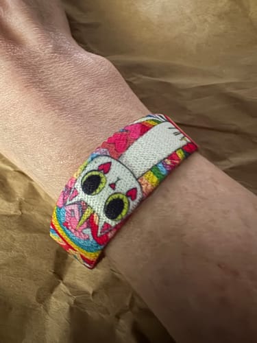 Close-up of a reviewer wearing the Sparkle on Bracelet, showing its playful and colorful caticorn design.