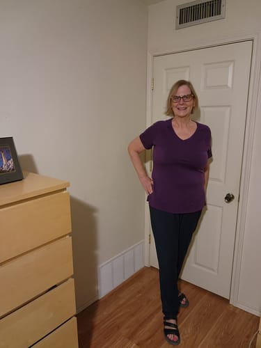Reviewer standing in a room, showing the full-length fit of the navy Nicole Tall Ankle Pants.