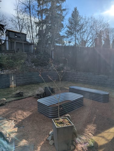 Customer's two assembled 17” Tall Modular garden beds sitting empty in a landscaped backyard.
