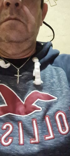 Primer plano de un cliente que reseña la Cadena Cuban Link, aunque lleva puesto otro collar.