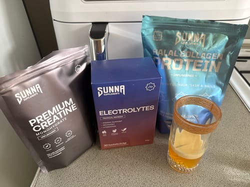 Customer's Ramadan Bundle supplements, including creatine, electrolytes, and collagen, on a counter next to a prepared drink.